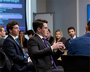 Conference room meeting of finance students and faculty