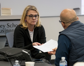 Executive Education professor reviewing a handout with a student