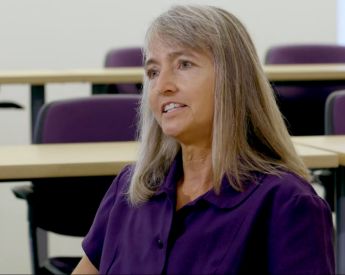 woman in purple shirt speaking