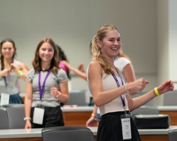 young women smiling and dancing in classrom
