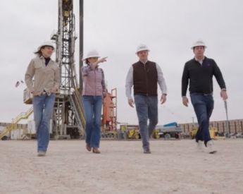 group students and advisor in the oilfield wearing helmets and protective gear