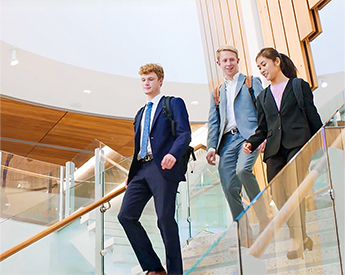 TCU Neeley students talking after class while walking down the stairs
