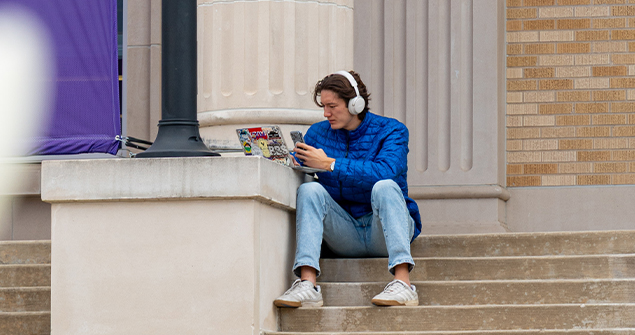 TCU graduate student doing homework on the library steps
