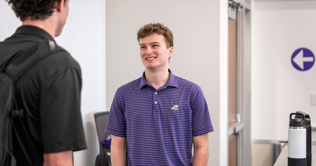 Smiling TCU Neeley student in a purple polo