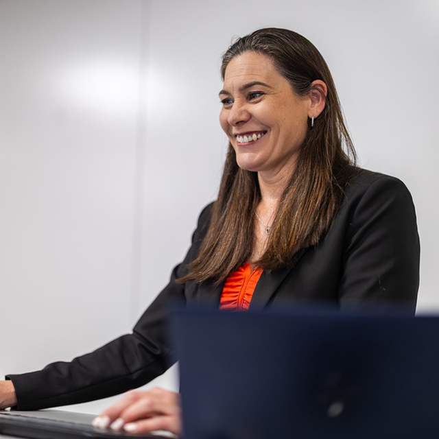 MBA student smiling at desk