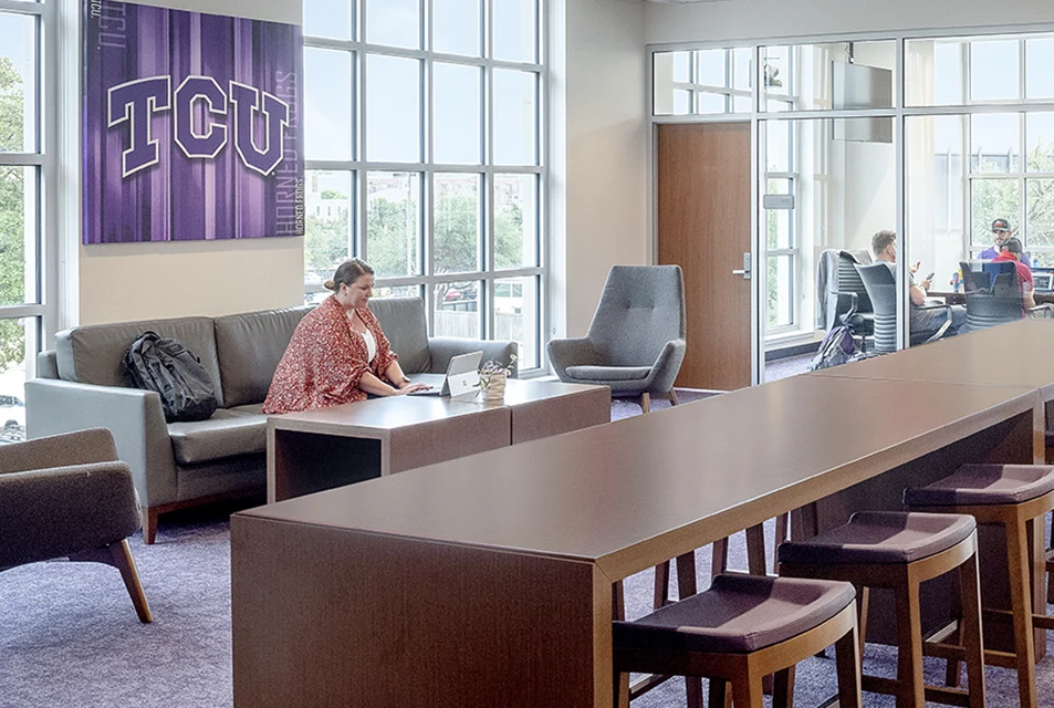 A student works on a laptop in the graduate lounge