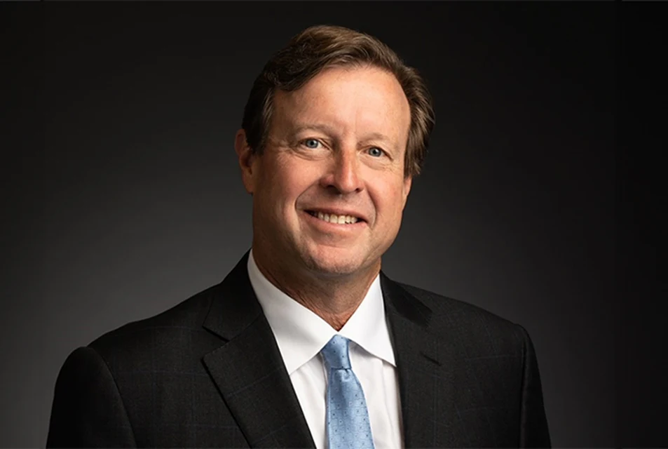 David May, wearing a black suit with light blue tie