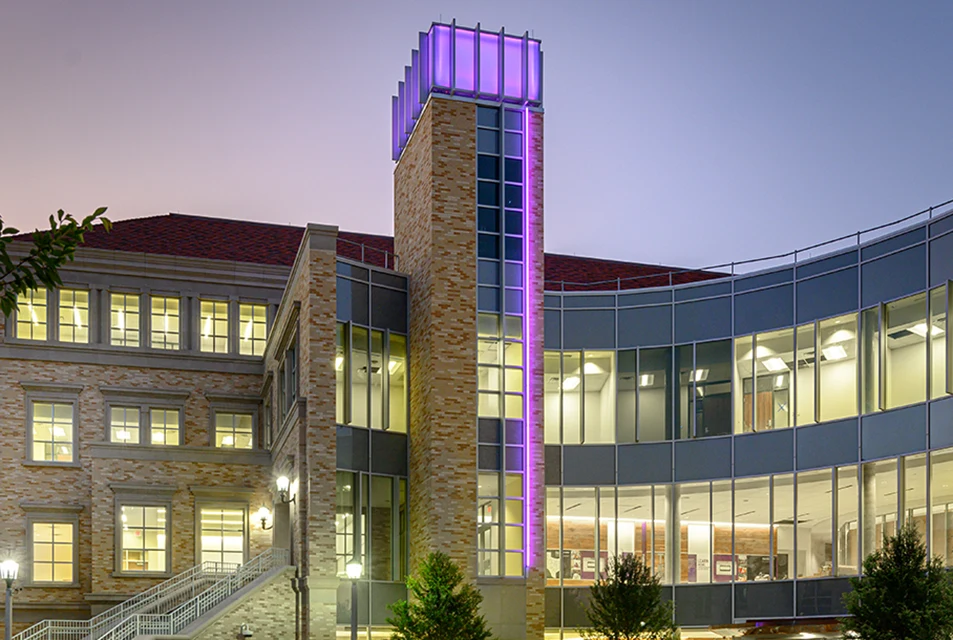 Neeley plaza at night, with tower illuminated in purple