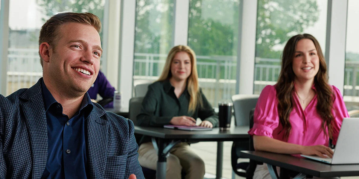 MBA students, taking notes and asking questions in a classroom
