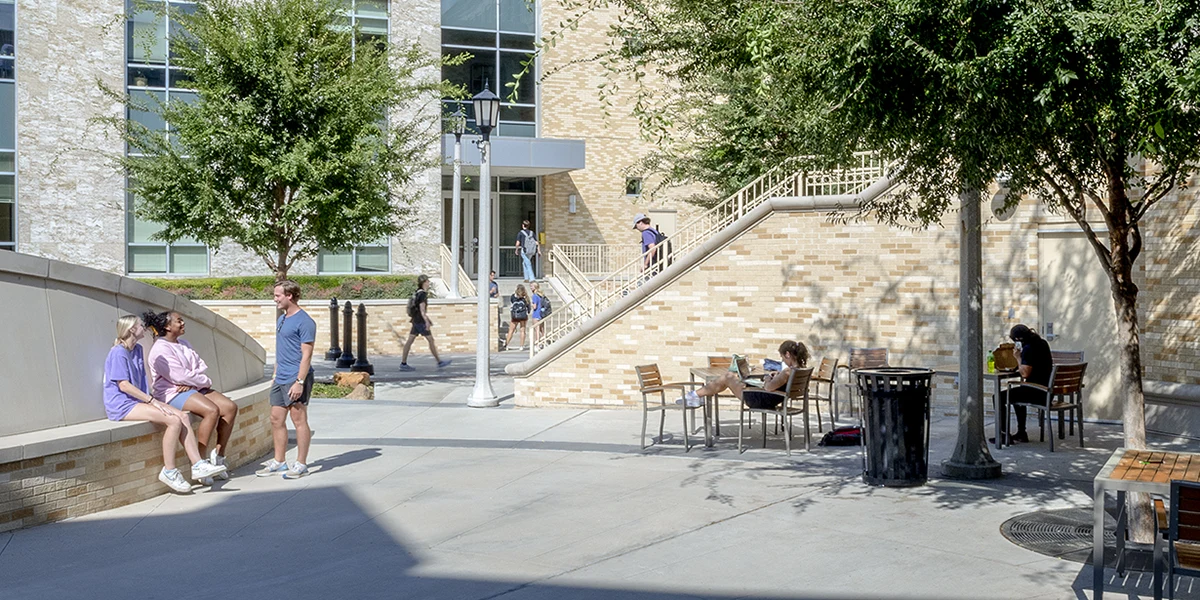 Students chat in small groups around Roach Plaza