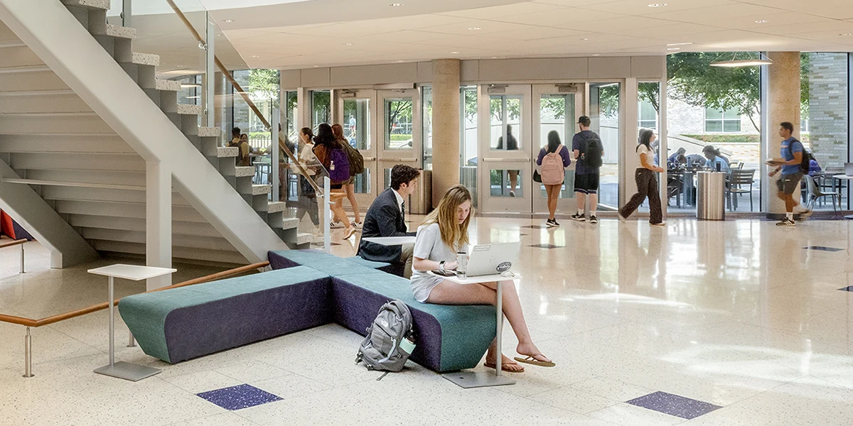 Students work on laptops in the Rotunda while others walk in and out