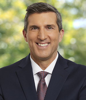 Brent Woodford, in a dark suit with purple tie