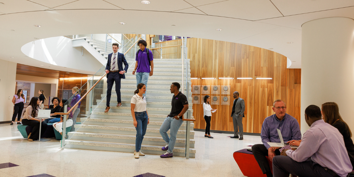 Students gather at the base of the staircase in Neeley. 